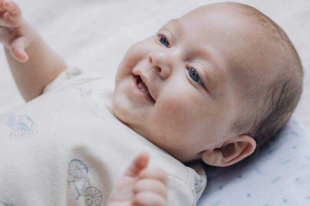 Baby met doorkomende tandjes lacht op een zachte deken