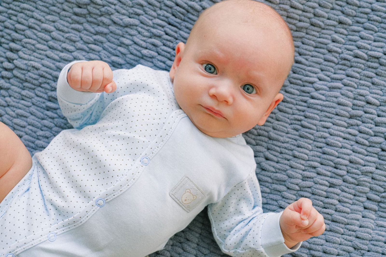 De meeste kwaaltjes bij een baby zijn onschuldig en gaan vanzelf over Alerte baby ligt rustig op een deken, meestal is een kwaaltje onschuldig