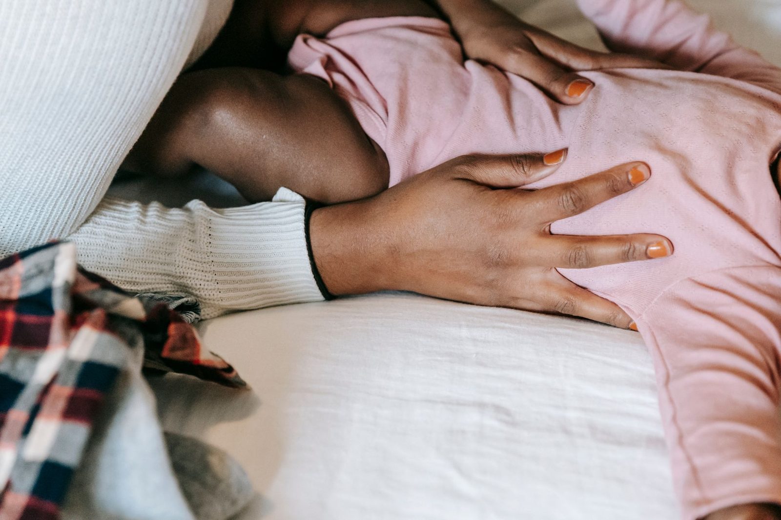 Let bij koorts vooral op het gedrag van je baby, niet alleen op de thermometer Ouder houdt rustig een liggende baby gezelschap die wat warm en hangerig is