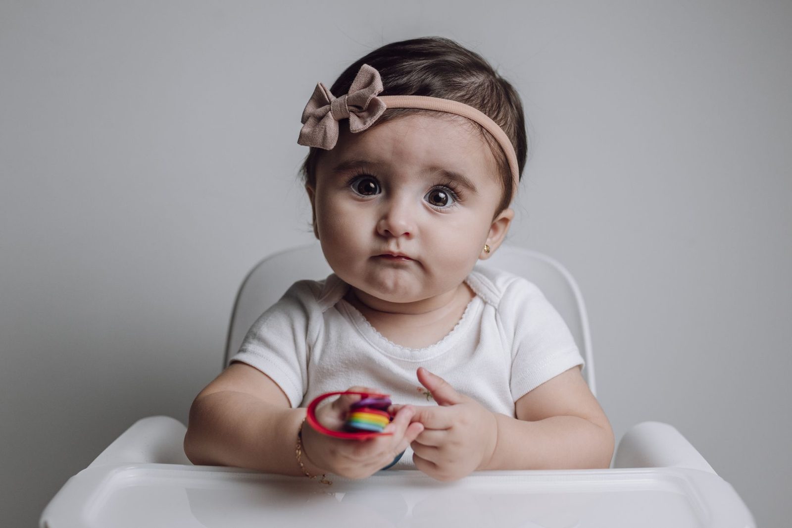 Een bijtring geeft tegendruk en verlicht de tandjespijn Baby houdt een gekleurde bijtring vast om op te bijten tegen de tandjespijn