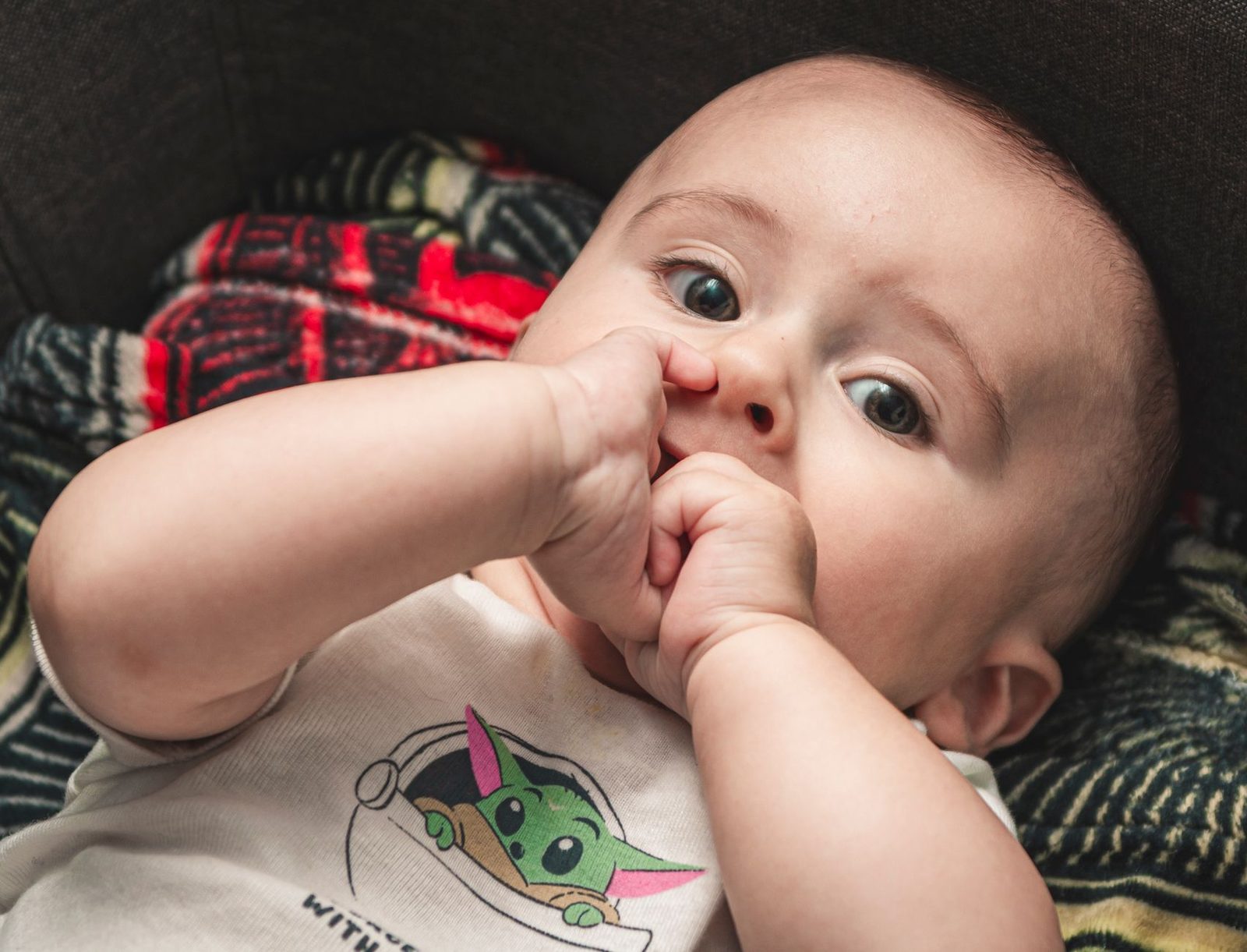 Op de vingers bijten hoort bij het doorkomen van de eerste tandjes Baby van een paar maanden bijt op zijn vingers, een vroeg teken dat de tandjes doorkomen